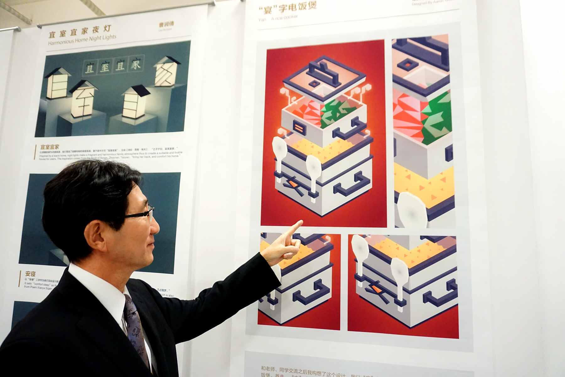 A man in a suit points at an isometric design of a rice cooker featuring with the Chinese character Yan.